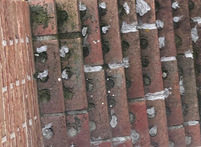 Brick wall with the old mortar ground out of the joints, ready to be repointed